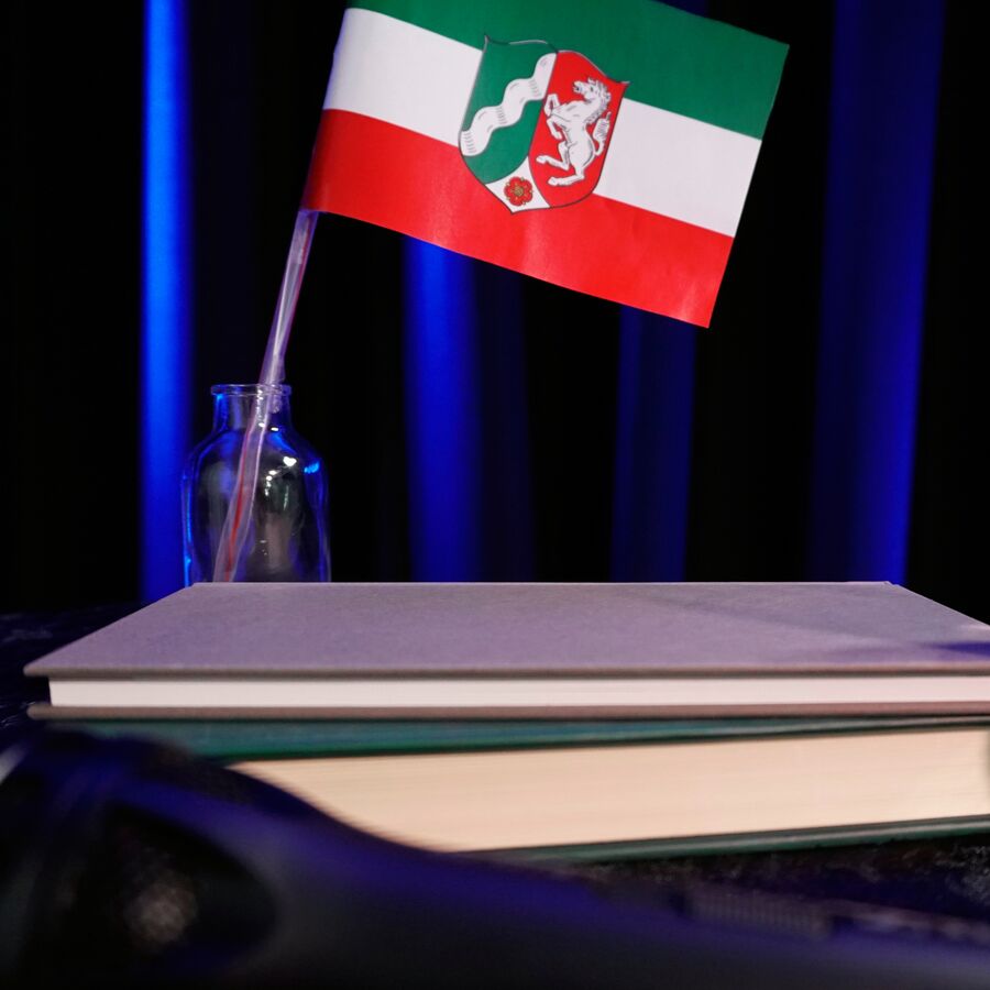 Fahne von NRW mit Büchern davor